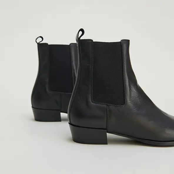 Boots with slight beveled heels and pointed toes in black leather