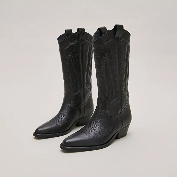 Pointed toe boots with exposed stitching in black grained leather