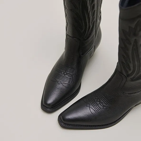 Pointed toe boots with exposed stitching in black grained leather