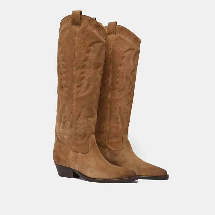 Pointed-toe boots with visible stitching in dark taupe suede