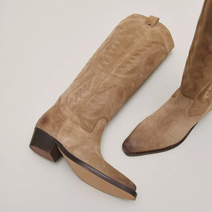 Pointed-toe boots with visible stitching in dark taupe suede