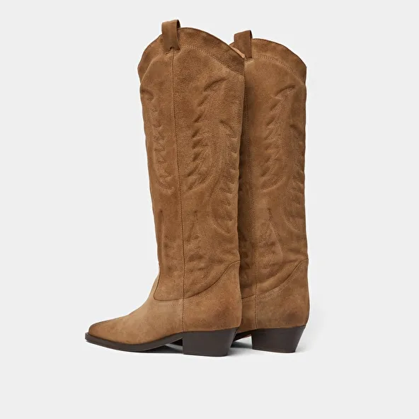 Pointed-toe boots with visible stitching in dark taupe suede